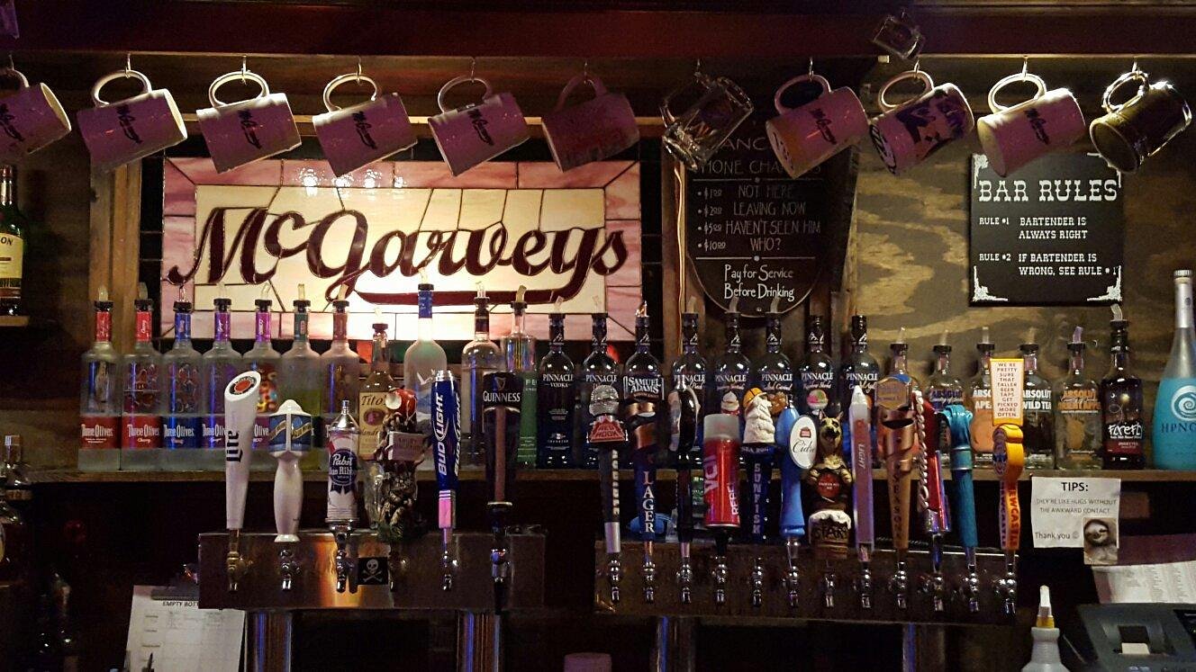 Inside McGarvey's Saloon — stained glass sign, beer taps, and hanging mugs